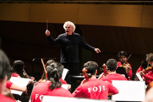 Afiche de "Revive la visita del famoso director de orquesta, Sir Simon Rattle, a Fundación CorpArtes"